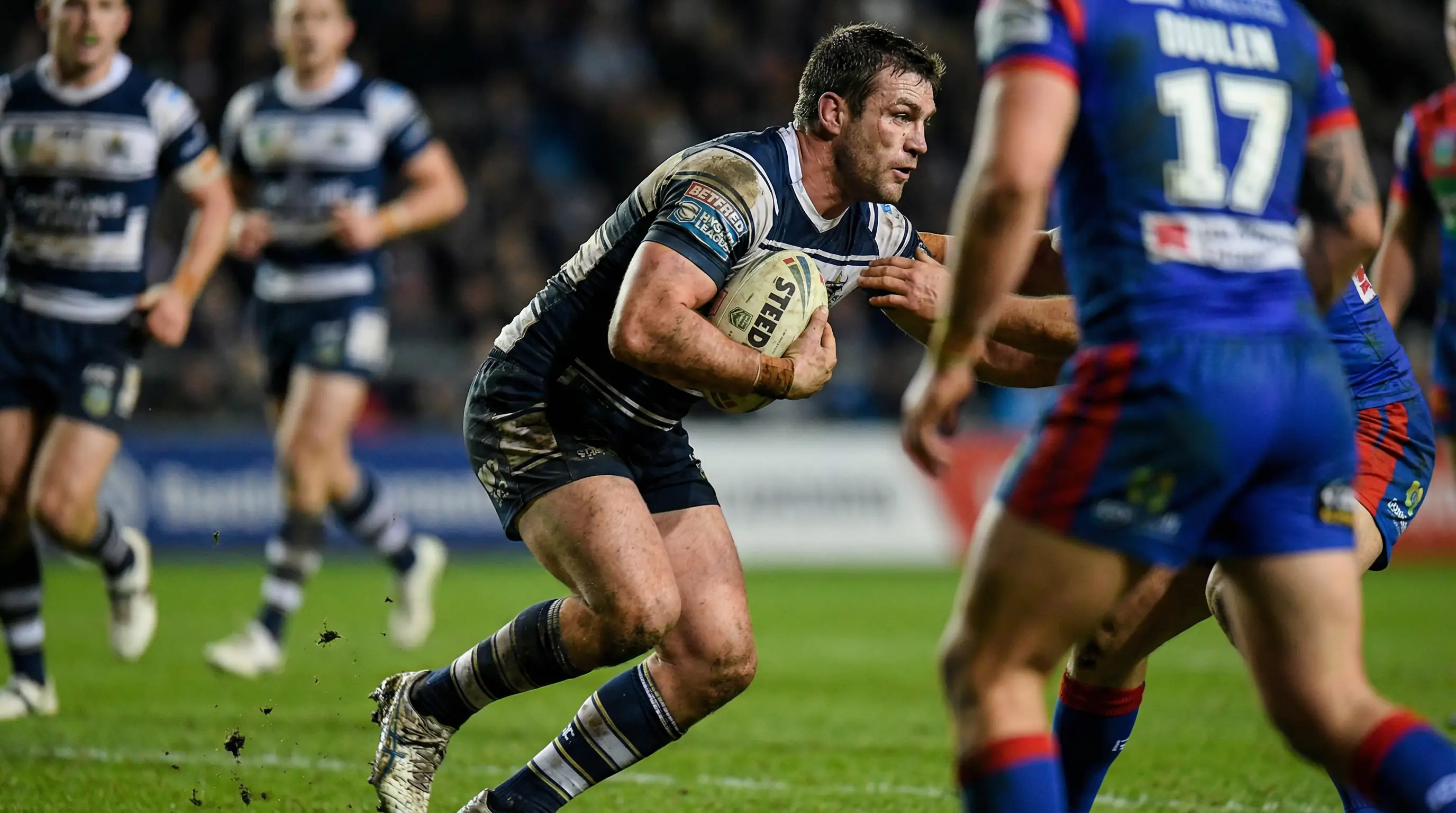 Rugby league player carrying the ball with determination during a professional match
