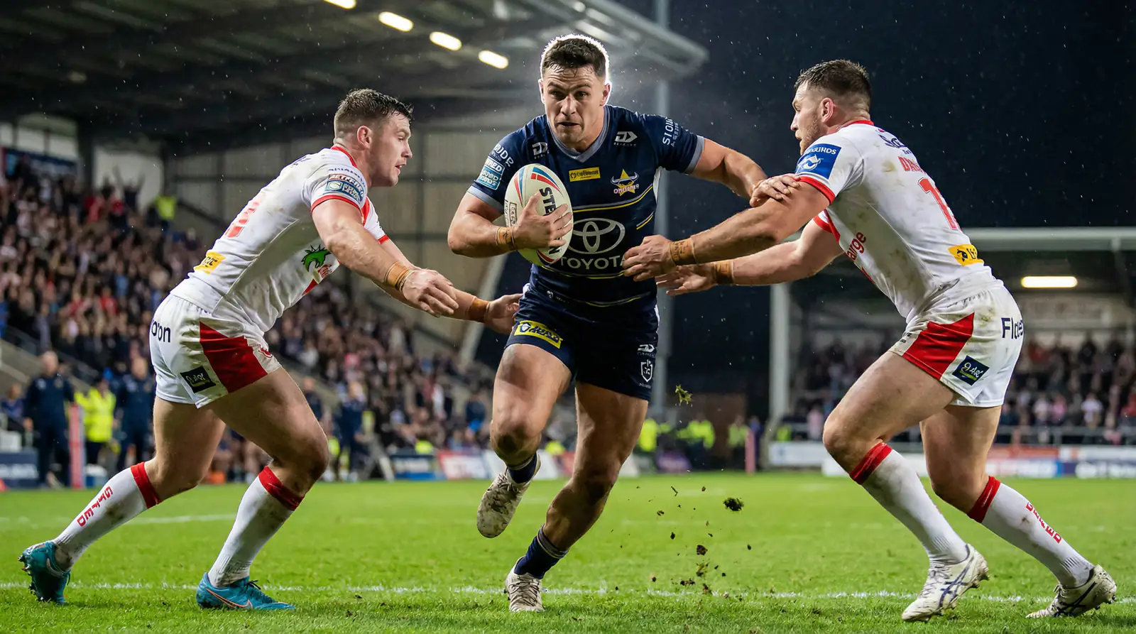 Rugby league underdog player breaking through a tackle during a competitive match